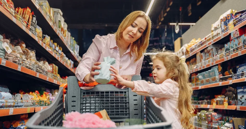Caregiver shopping with a child, representing spending priorities for a Child Support Grant household
