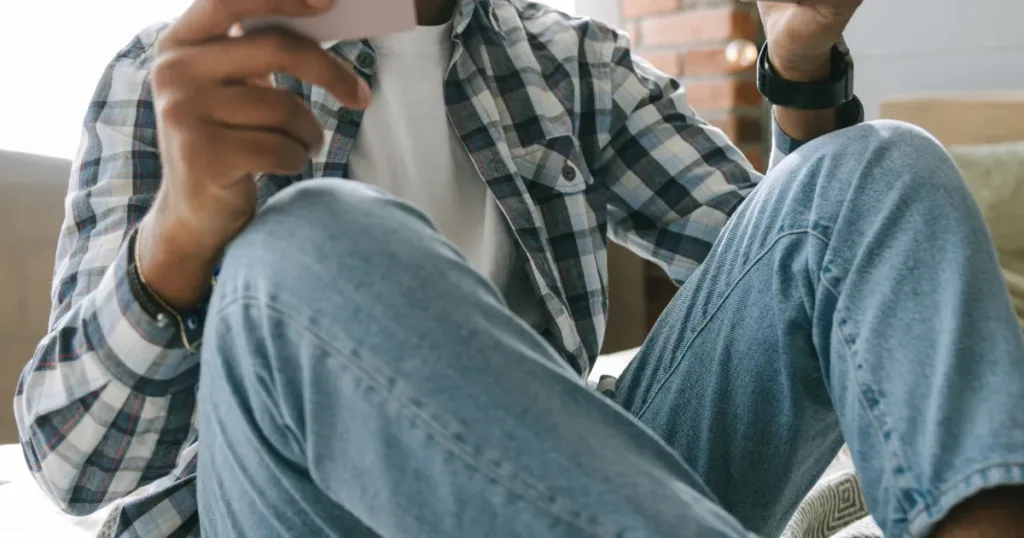 Man checking a bank statement and card on his phone