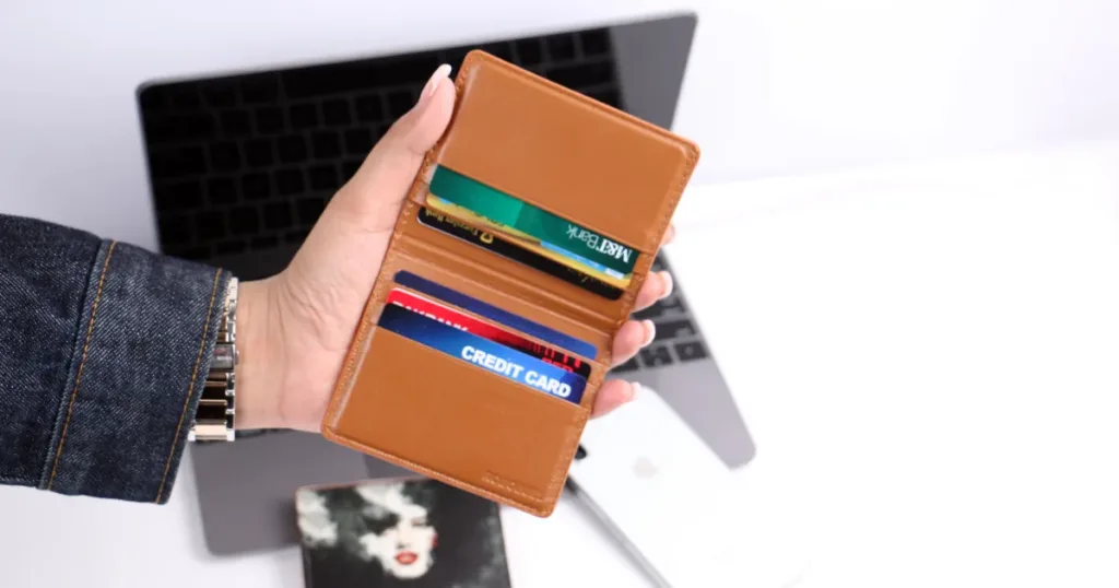 Hand holding a wallet full of bank cards