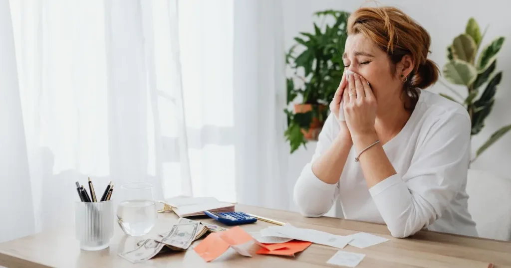 Person worried while reviewing bills and financial paperwork