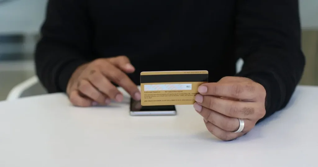 Person comparing credit card offers on a phone in South Africa