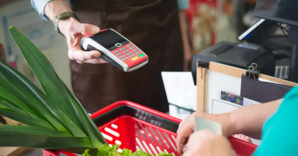 Person paying with a credit card while grocery shopping