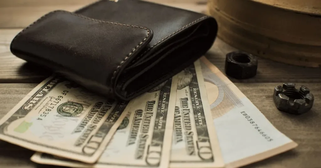 Person checking a wallet and cash while budgeting a small credit limit
