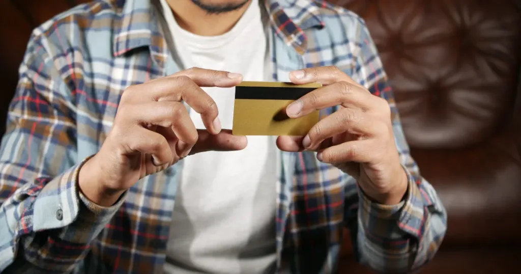 Hand holding a gold credit card